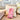 Pink and white striped bag labeled 'My Goody Bag' on a beige couch with pillows.
