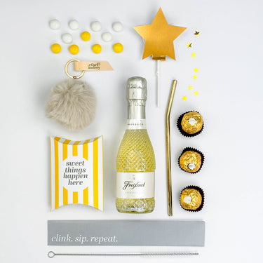 Gift set with mini bottle of Freixenet, chocolate candies, and decorative items on a white background