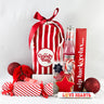 Our best selling bag with a festive twist this season. Fever tree, reusable straw se, cracker and treats surround a red striped goody bag with red ribbon against a plan background by MY Goody Bag.