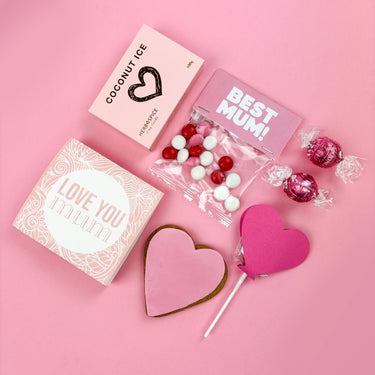 Greeting cards, cookies, and candies on a pink background