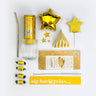 Collection of gold-themed items including a straw, can, stars, and a box on a white background.